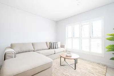 a white living room with a couch and a table at 113 Paarl 2 Bedroom Lux Aprt With Parking & Aircon in Paarl