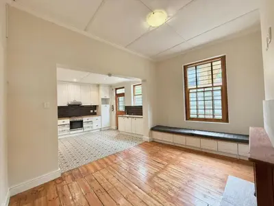 an empty room with a large kitchen with wooden floors at 3 Bedroom Vintage Home in Cape Town