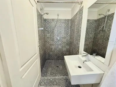 a bathroom with a sink and a shower at 3 Bedroom Vintage Home in Cape Town