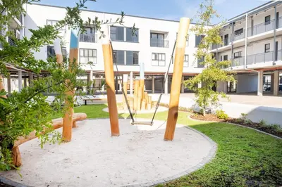 a swing in a park in front of a building at 116 Paarl - Lux 1 Bedroom Apt with AC and Parking in Paarl