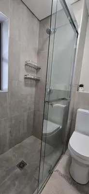 a bathroom with a glass shower with a toilet at Ebbies place in Cape Town