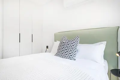 a bedroom with a white bed with pillows on it at 213 Paarl 2 Bedroom Lux Aprt With Parking & Aircon in Paarl