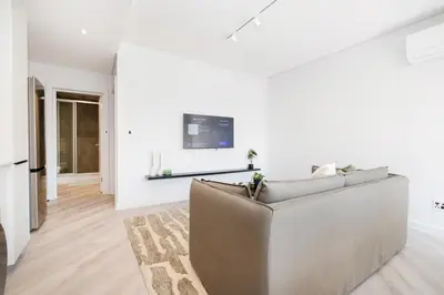 a living room with a couch and a tv on a wall at 216 Paarl Lux 1 Bdrm Apt with Parking and AC in Paarl