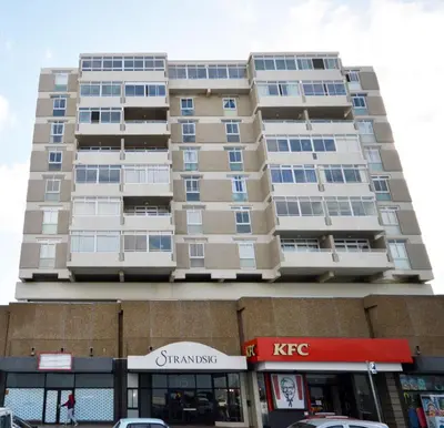a tall apartment building in front of a store at Strandsig 308, 96 beach road in Strand
