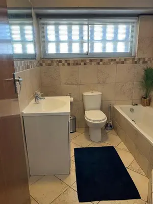 a bathroom with a toilet and a sink and a tub at Strandsig 308, 96 beach road in Strand