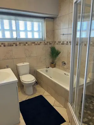 a bathroom with a toilet and a tub and a sink at Strandsig 308, 96 beach road in Strand