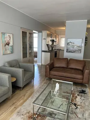 a living room with a couch and a glass table at Strandsig 308, 96 beach road in Strand