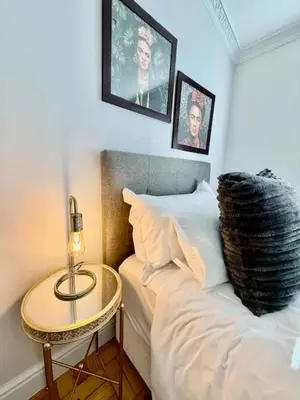 a bedroom with a bed and a table with a lamp at 26 at Blumenhof in Stellenbosch