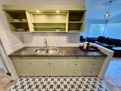 a kitchen with a sink and a living room at 26 at Blumenhof in Stellenbosch