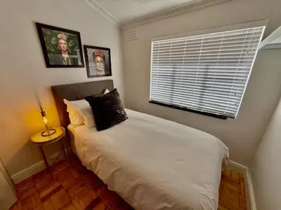 a bedroom with a bed with a pillow and a window at 26 at Blumenhof in Stellenbosch