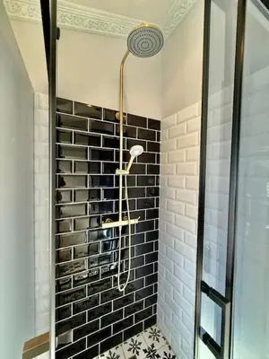 a shower in a bathroom with black and white tiles at 26 at Blumenhof in Stellenbosch