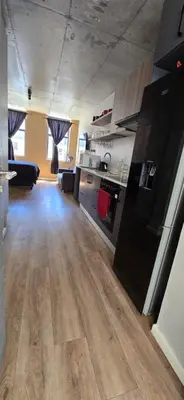 a large kitchen with wooden floors in a room at Ebbies place in Cape Town