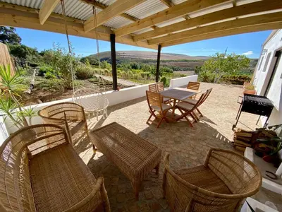 a patio with a table and chairs and a grill at Beaumont Family Wines in Botrivier
