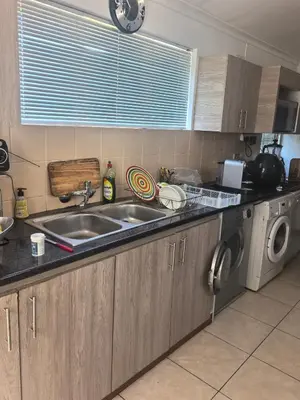 a kitchen with a sink and a washing machine at 22 on BREEZAND in Cape Town