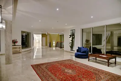 a large living room with a blue chair and a rug at The Coach House at Val du Charron in Wellington