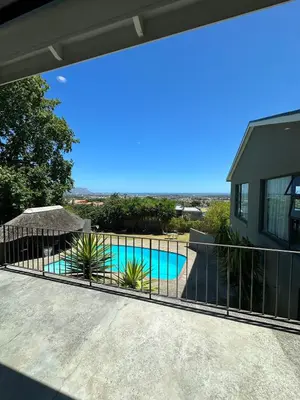 a view of a swimming pool behind a fence at Little Nest in Somerset West