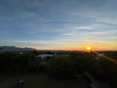 a sunset with the sun setting in the distance at Little Nest in Somerset West