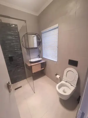 a small bathroom with a toilet and a mirror at Milino Guest House in Cape Town