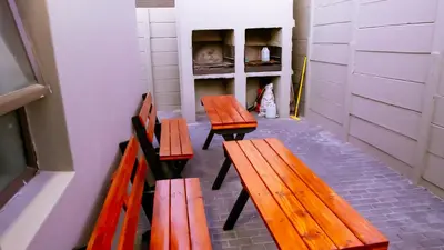 three wooden benches in a room with a shelf at DC Guest House in Avondale