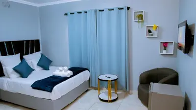 a bedroom with a bed and a chair at DC Guest House in Avondale
