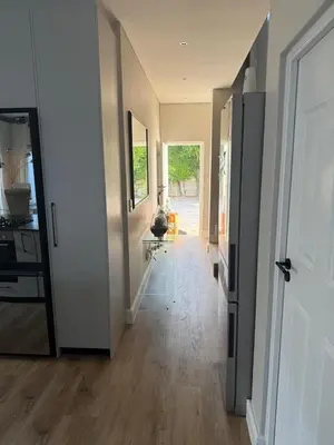 a hallway of a home with a door and a room with a hallway at Durbanville apartment in Durbanville