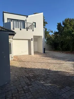a large white house with a garage at Durbanville apartment in Durbanville