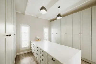 a white kitchen with white cabinets and white counters at Coats Haven in Hermanus