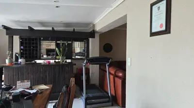 a living room with a treadmill next to a table at Nyati in Cape Town