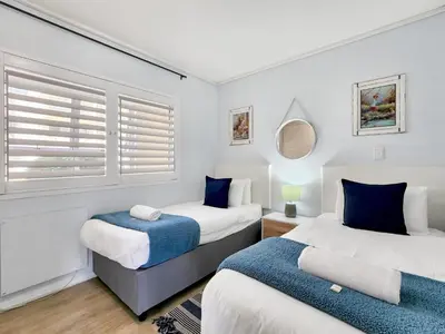 a bedroom with two beds and a window at Seaside Serenity with Ocean View in Cape Town