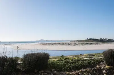 a beach with a person walking on the beach at Seaside Serenity with Ocean View in Cape Town