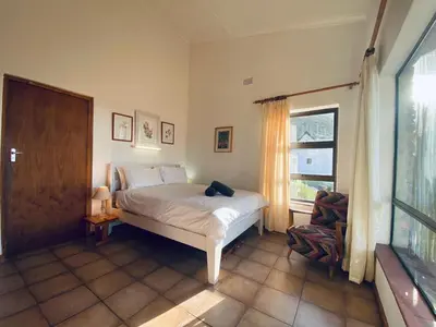 a bedroom with a bed and a window at Hillside View in Pringle Bay