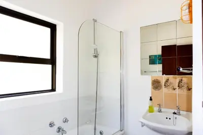 a bathroom with a shower and a sink at Hillside View in Pringle Bay