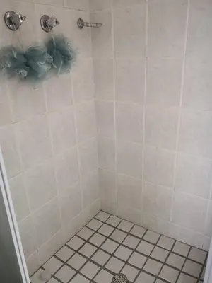 a bathroom with a shower with white tile at Duplex in Tableview in Cape Town