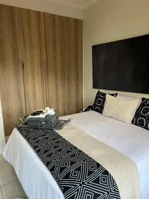 a bedroom with a bed with a bag on it at The Jade, Somerset West in Strand