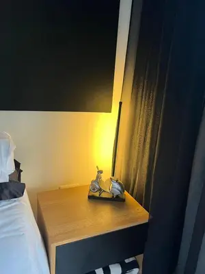 a nightstand with a stuffed animal on it next to a bed at The Jade, Somerset West in Strand