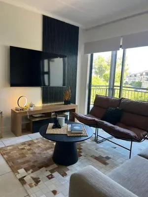 a living room with a couch and a tv at The Jade, Somerset West in Strand