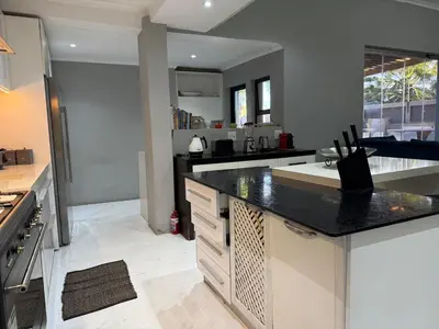 a kitchen with a black counter top in a room at Centrally located 11 sleeper house near Canal Walk in Cape Town