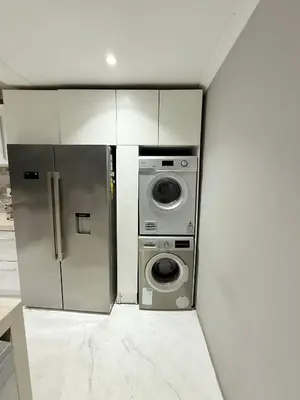 a kitchen with a refrigerator and a washing machine at Centrally located 11 sleeper house near Canal Walk in Cape Town