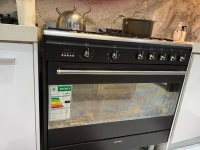 a black stove with a pot on top of it at Centrally located 11 sleeper house near Canal Walk in Cape Town