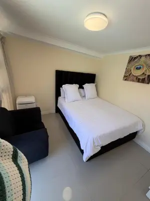 a bedroom with a bed and a couch at Joy House in Cape Town