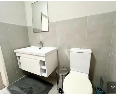 a bathroom with a white toilet and a sink at Luxe Manhattan Quarters in Cape Town