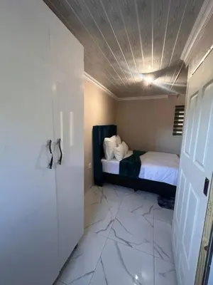 a bedroom with a bed and a white floor at New Dawn Guest House in Goodwood