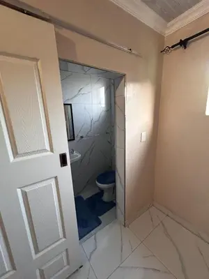 a bathroom with a toilet and a glass shower door at New Dawn Guest House in Goodwood