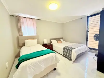 a bedroom with two beds and a window at Spacious house for 11 Guests near Canal Walk Mall in Cape Town