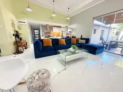 a living room with a blue couch and a table at Spacious house for 11 Guests near Canal Walk Mall in Cape Town
