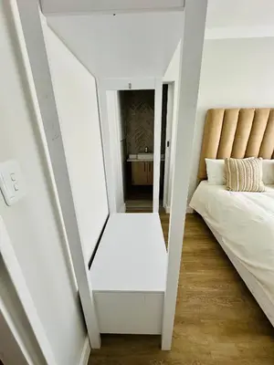 a small bedroom with a bed and a mirror at Spacious Family Friendly Richwood in Cape Town