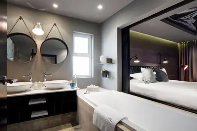 a bathroom with two sinks and a large mirror at Majeka House Boutique Hotel by The Living Journey Collection in Stellenbosch