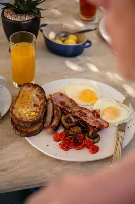 a plate of breakfast food with eggs bacon and toast at Majeka House Boutique Hotel by The Living Journey Collection in Stellenbosch