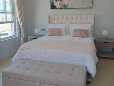a bedroom with a large bed with a large white bedspread at L'Ermitage Villa Francois in Franschhoek