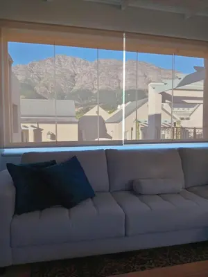 a couch in a living room with a large window at L'Ermitage Villa Francois in Franschhoek